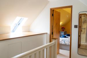a room with a staircase and a bedroom with a bed at Mattie's Loft in Bletchingley