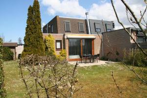 une maison avec une cour et une table devant elle dans l'établissement Lamsoor 2A*, à Nieuwvliet