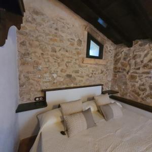 um quarto com uma cama numa parede de pedra em Agroturismo Son Torrat Apartment Es Forn em Petra