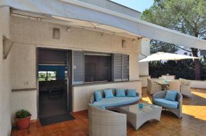 une terrasse avec des chaises, une table et un parasol dans l'établissement Bed and Breakfast La Villa AMBIENTI SANIFICATI CON GENERATORE DI OZONO, à Bari