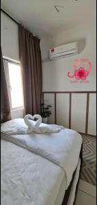 - une chambre avec un lit doté de draps blancs et une fenêtre dans l'établissement Sakura Thirty Guest House , Homestay Seri Iskandar, à Seri Iskandar