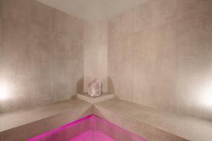 a room with a rock on a wall with pink lights at Der Rindererhof in Tux