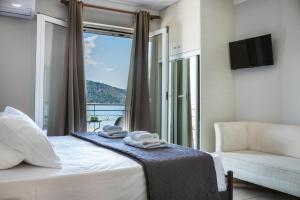 sypialnia z łóżkiem, krzesłem i oknem w obiekcie Fidias city rooms w mieście Argostoli