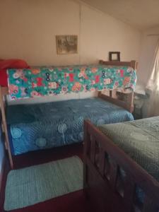 1 dormitorio con 2 camas y manta verde en Cabañas Josabi, en Concepción