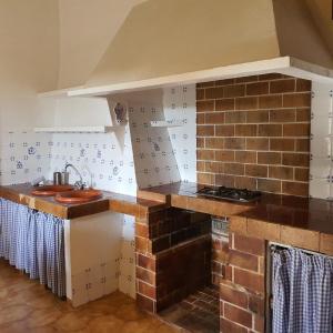 uma cozinha com um lavatório e uma parede de tijolos em Agroturismo Son Torrat Apartment Es Moli em Petra