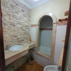 uma casa de banho com um lavatório e uma parede de pedra em Agroturismo Son Torrat Apartment Es Moli em Petra