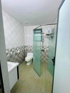 een badkamer met een toilet en een glazen douchedeur bij Skyview Homstay & Coffee in Kon Tum Kơ Nâm