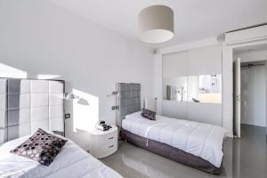 ein weißes Schlafzimmer mit 2 Betten und einem Spiegel in der Unterkunft Luxueux appartement à 50 m de la Croisette in Cannes
