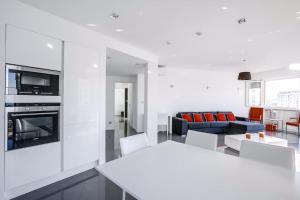 eine Küche und ein Wohnzimmer mit weißen Wänden und weißen Möbeln in der Unterkunft Luxueux appartement à 50 m de la Croisette in Cannes