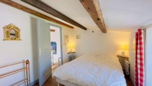 a bedroom with a white bed and two lamps at Petite maison de village avec étage in La Couarde-sur-Mer