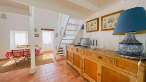 a room with a table with a blue lamp on a wooden cabinet at Petite maison de village avec étage in La Couarde-sur-Mer