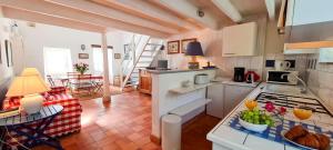 a kitchen and a living room with a table at Petite maison de village avec étage in La Couarde-sur-Mer