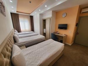 a hotel room with two beds and a television at Venera Hotel in Baku
