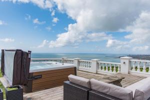 a hot tub on a deck with a view of the ocean at Harbour Heights by Bloom Stays in Folkestone