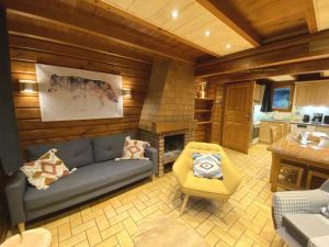 a living room with a couch and a fireplace at LE LOUP Chalet en bois in La Bresse