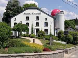 een wit gebouw met een bord aan de zijkant bij Maison des Fées d'Achouffe in Houffalize