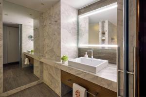 a bathroom with a sink and a mirror at Angsana Corfu Resort & Spa in Benitses