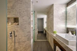 a bathroom with a sink and a shower at Angsana Corfu Resort & Spa in Benitses