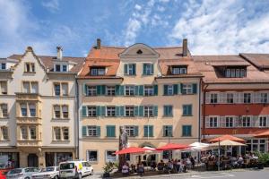 a large building with people sitting in front of it at Cityapartments im ältesten Haus von Ravensburg in Ravensburg