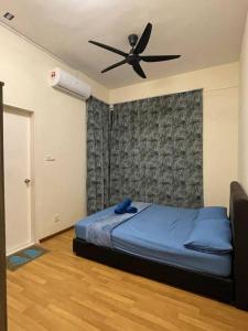 a bedroom with a bed with a ceiling fan at Aurora’s Homestay Sandakan in Sandakan