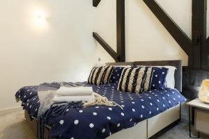 Schlafzimmer mit einem Bett mit blauer Bettwäsche und Kissen in der Unterkunft Modern 2 Bedroom with 75” TV & Free Wi-Fi in Bradford