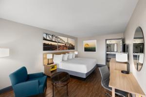 a hotel room with a bed and a blue chair at Days Inn by Wyndham Carlisle in Carlisle