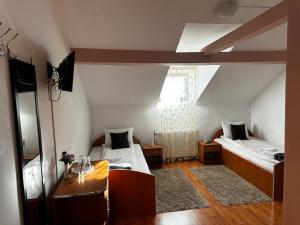 Habitación con 2 camas y mesa. en Pensiunea Daiadela, en Duşeşti