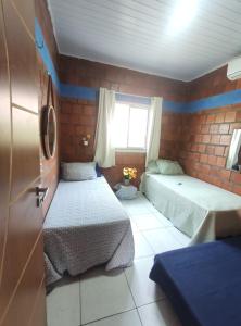 a small room with two beds and a window at Casa de Temporada de Amaro in Santo Amaro