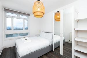 a white bedroom with a bed and a window at Gorgeous 2BDR Flat in Shoreditch in London