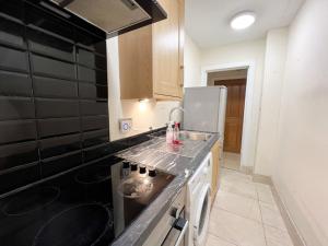 a kitchen with a sink and a stove top oven at Charming 2Bed Apartment in the Heart of Edinburgh in Edinburgh