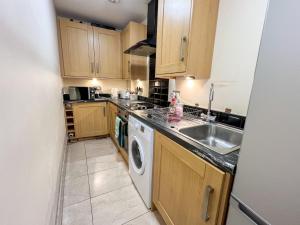 a kitchen with a sink and a washing machine at Charming 2Bed Apartment in the Heart of Edinburgh in Edinburgh