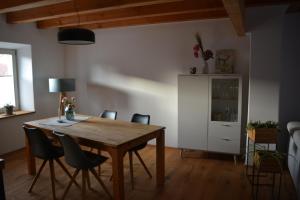 a dining room with a wooden table and chairs at Ferienwohnung Hofgut in Momlingen