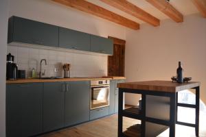 a kitchen with gray cabinets and a wooden table at Ferienwohnung Hofgut in Momlingen