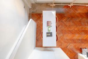 Tastefully Curated Mezzanine Studio Flat Hackney! في لندن: غرفة ذات باب أبيض وأرضيات خشبية