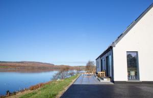 a white building with a view of a lake at Daisy Cottage in Eyre