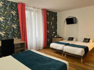 um quarto de hotel com duas camas e uma televisão em Empire Hôtel em Nîmes