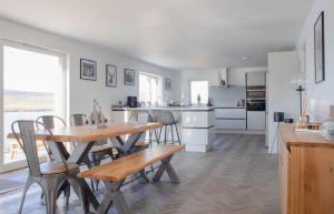 a kitchen and dining room with a wooden table and chairs at Daisy Cottage in Eyre