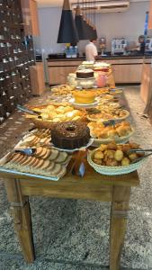 a table with many different types of food on it at Flat Águas da Serra - com acesso ao rio in Rio Quente