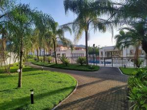 einen Fußweg durch einen Park mit Palmen in der Unterkunft Rio Marina Resort in Mangaratiba