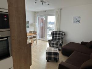 - un salon avec un canapé et une chaise dans l'établissement Moderne Ferienwohnung an der Ostsee im Haus Leuchtfeuer, à Diedrichshagen