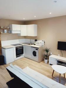 a kitchen with white cabinets and a washer and dryer at Rousquille: Patio au RDC d'une maison calme in Port-Vendres