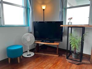 a living room with a television and a fan at Dolphins and Whales in Ishigaki Island