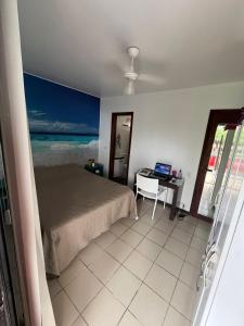 Un dormitorio con una cama y un escritorio con una computadora portátil. en APARTAMENTO EM CONDOMÍNIO- acolhedor-FRENTE MAR-ENSEADA-TORTUGA, en Guarujá