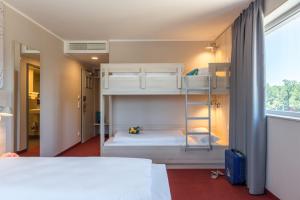 a bedroom with two bunk beds and a window at Serways Hotel Steigerwald in Wachenroth