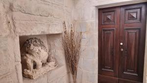 a statue of a lion on a wall next to a door at Servants' Quarters Studio Apartment in Valletta