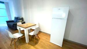 a small kitchen with a table and a refrigerator at Elegante estudio en Valencia in Valencia