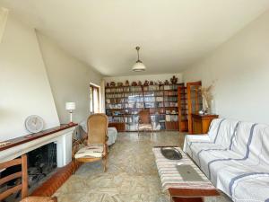 a living room with a couch and a fireplace at Villa Les Oliviers proche centre Porto-Vecchio in Porto-Vecchio