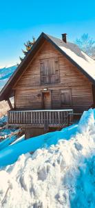 una cabina in legno con neve di fronte di Chalet St Lary Pla d'Adet a Saint-Lary-Soulan