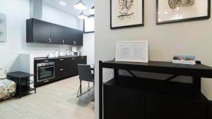 a kitchen with a black counter and a table at Italianway - Jommelli 44 in Milan