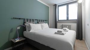 a bedroom with a large white bed and a window at Italianway - Jommelli 44 in Milan